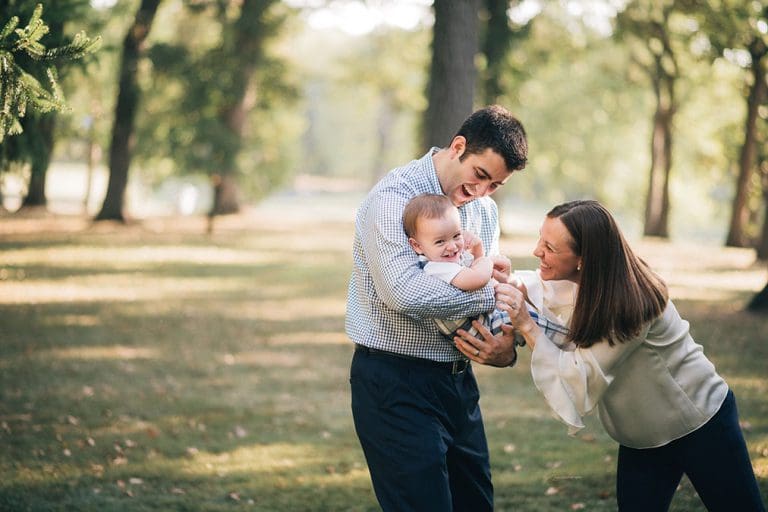 Family holding baby laughing