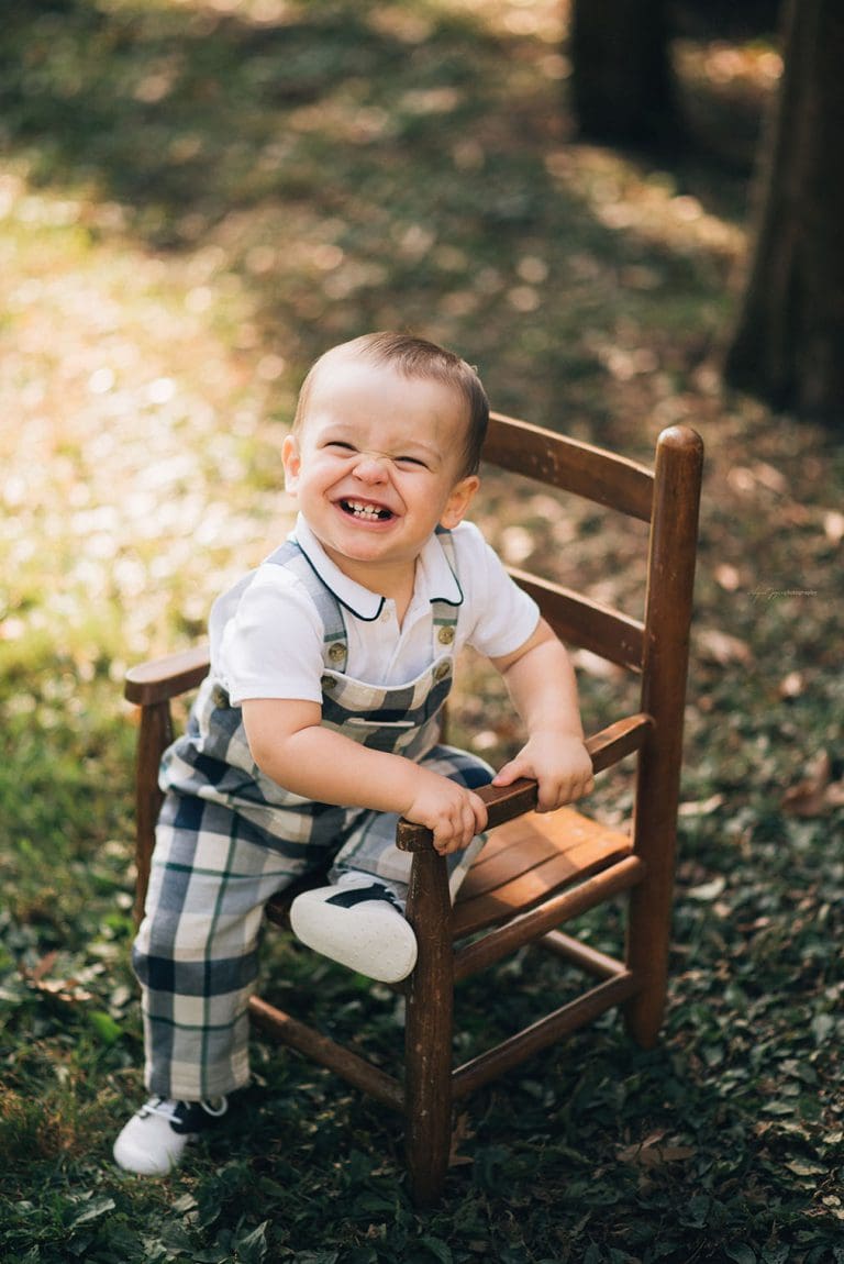 baby with big smile while sitting on rocking chair