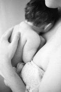 mom holds baby against her chest for mommy and me photoshoot